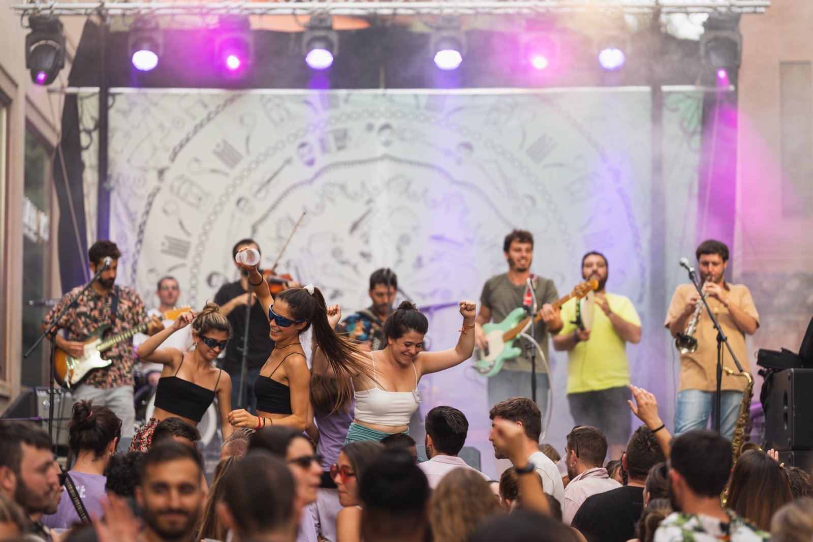 El grup tocant damunt de l'escenari en un festival de dia