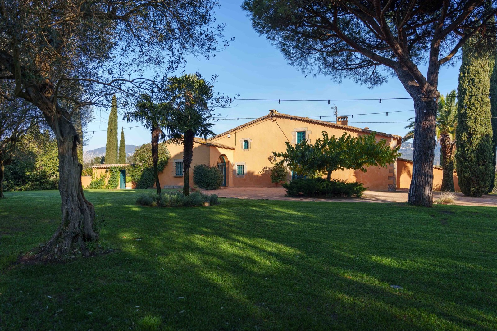 Masia entre xiprers amb el jardí al davant