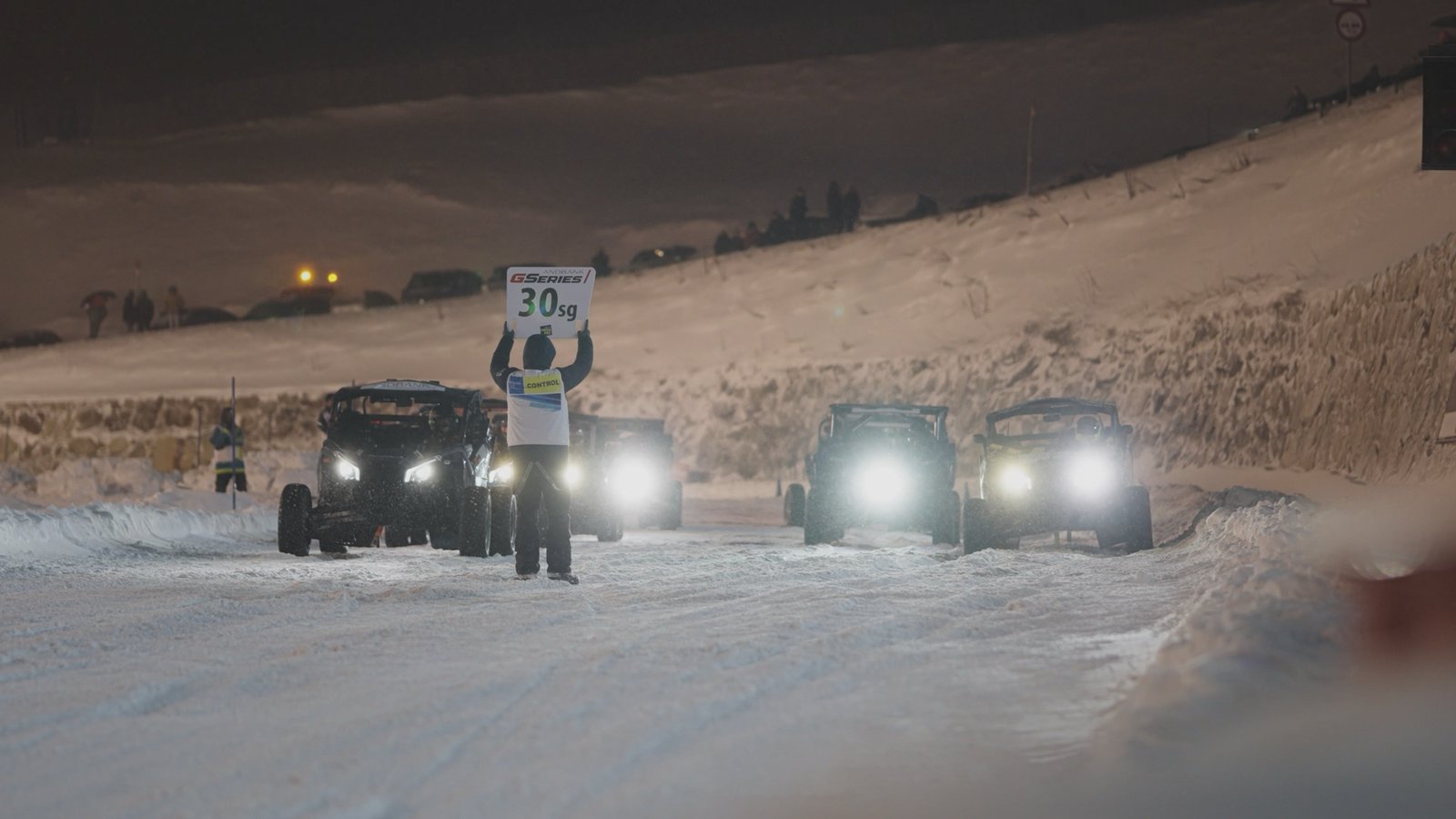 Cotxes de ral·li amb els focus encesos sobre la neu